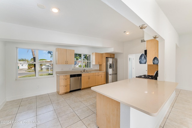 kitchen with kitchen peninsula, light brown cabinets, stainless steel appliances, and light tile patterned floors