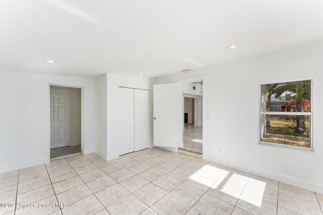 empty room featuring light tile patterned floors and ceiling fan