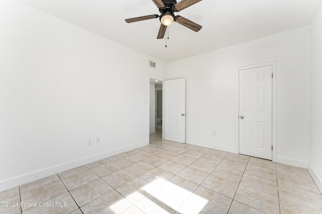 tiled empty room with ceiling fan