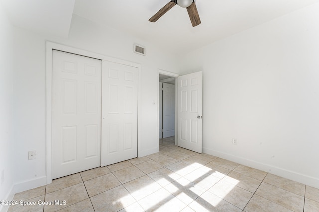 unfurnished bedroom featuring ceiling fan, a closet, and light tile patterned floors