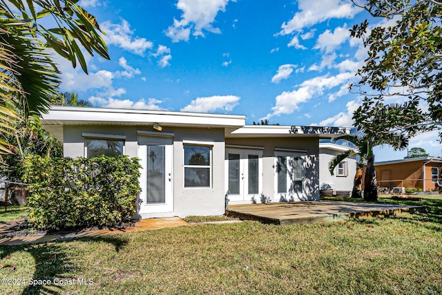 rear view of property with french doors and a yard