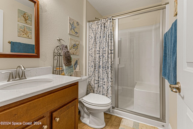 bathroom featuring a textured ceiling, walk in shower, hardwood / wood-style floors, vanity, and toilet