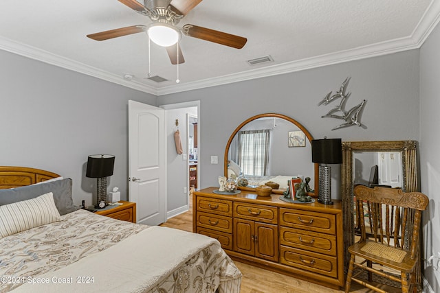 bedroom with a textured ceiling, crown molding, ceiling fan, and light hardwood / wood-style flooring