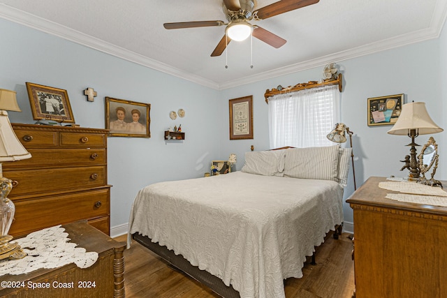 bedroom featuring ornamental molding, dark wood-type flooring, and ceiling fan