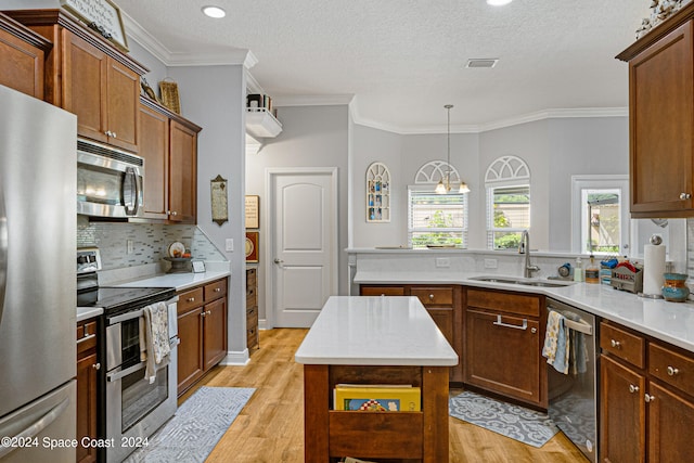 kitchen with stainless steel appliances, light hardwood / wood-style floors, a kitchen island, and sink