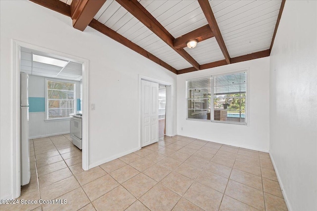 spare room featuring wood ceiling, lofted ceiling with beams, and light tile patterned floors