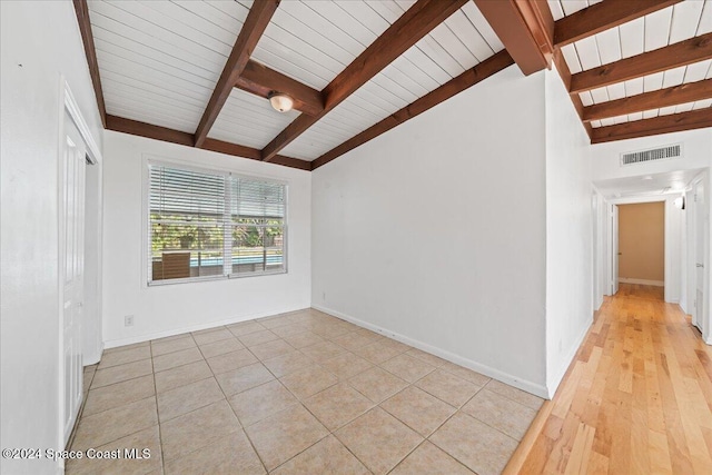 empty room featuring lofted ceiling with beams, light hardwood / wood-style floors, and wooden ceiling