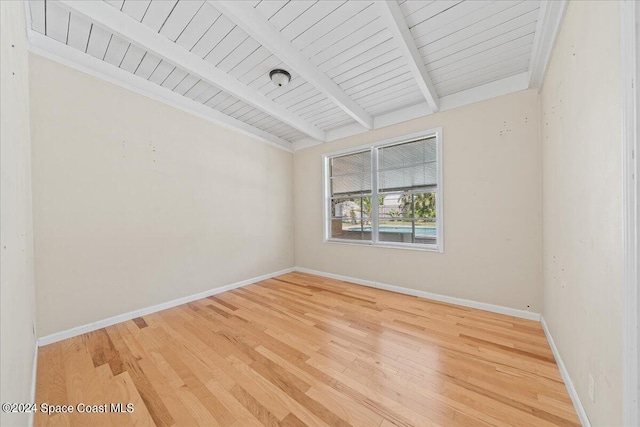 empty room with beam ceiling, wood ceiling, and wood-type flooring