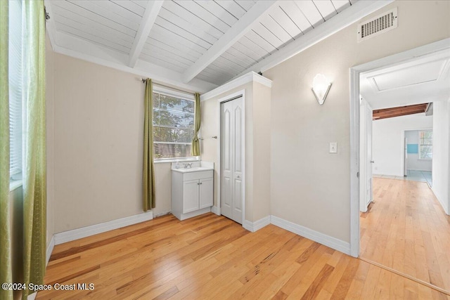 hall featuring beamed ceiling, light hardwood / wood-style flooring, and wooden ceiling