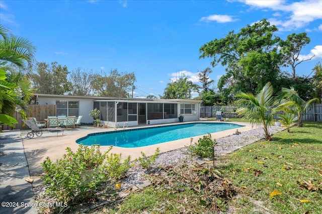 view of swimming pool featuring a patio area and a sunroom