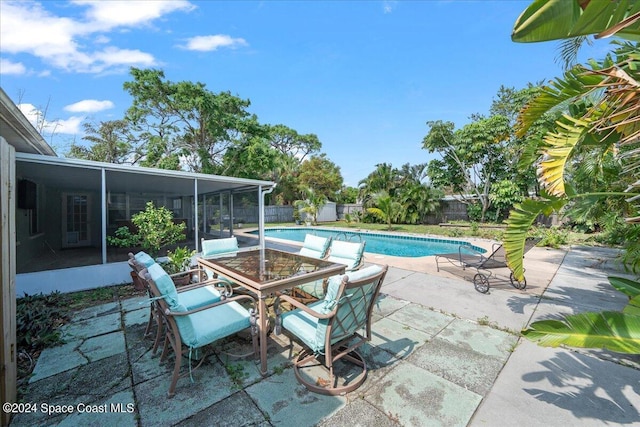 view of swimming pool with a patio area and a sunroom