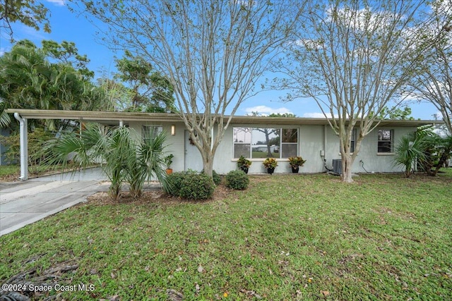 ranch-style home with cooling unit, a front yard, and a carport