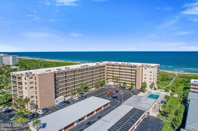 drone / aerial view featuring a water view and a beach view