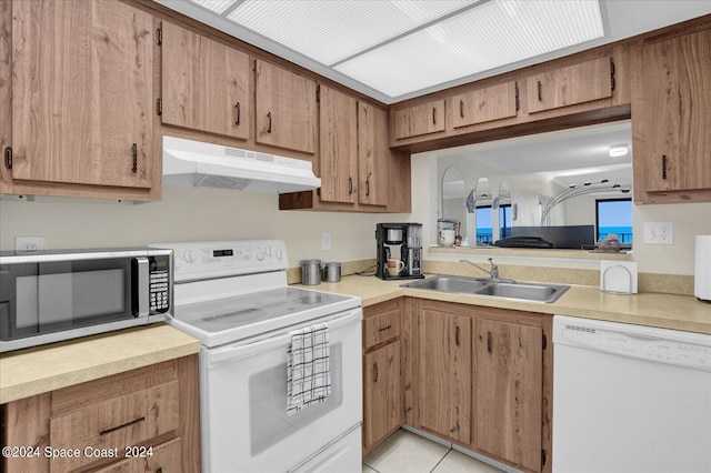 kitchen with white appliances, sink, and light tile patterned floors