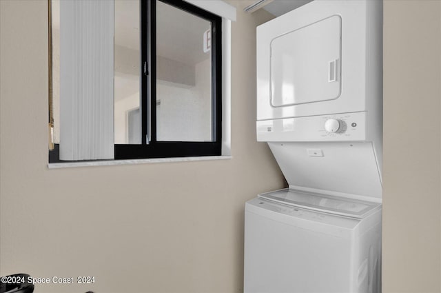 clothes washing area with stacked washer and dryer