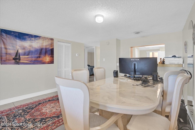 tiled dining area with a textured ceiling