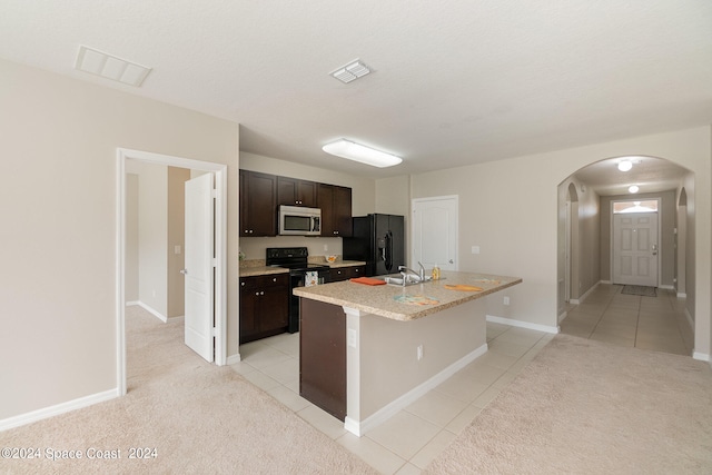 kitchen with light carpet, an island with sink, black appliances, dark brown cabinetry, and sink