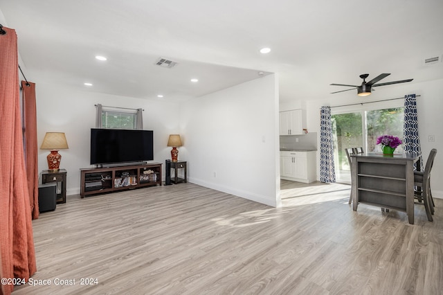 living room with ceiling fan and light hardwood / wood-style floors