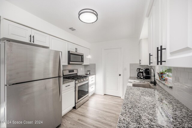 kitchen featuring light stone counters, white cabinetry, and appliances with stainless steel finishes