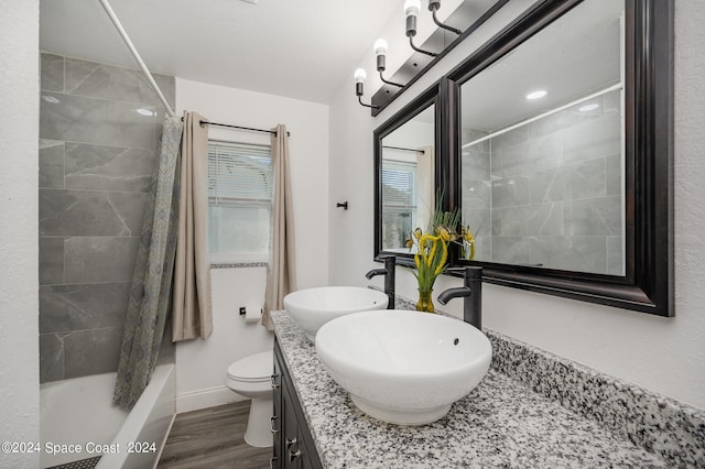 full bathroom featuring vanity, toilet, hardwood / wood-style floors, and tiled shower / bath combo