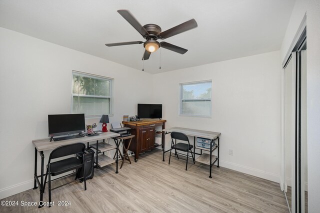 home office featuring light hardwood / wood-style floors, plenty of natural light, and ceiling fan