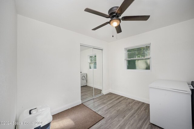 spare room featuring light wood-type flooring, washer and dryer, and ceiling fan