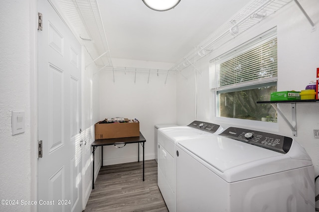 clothes washing area featuring washer and dryer and light hardwood / wood-style floors