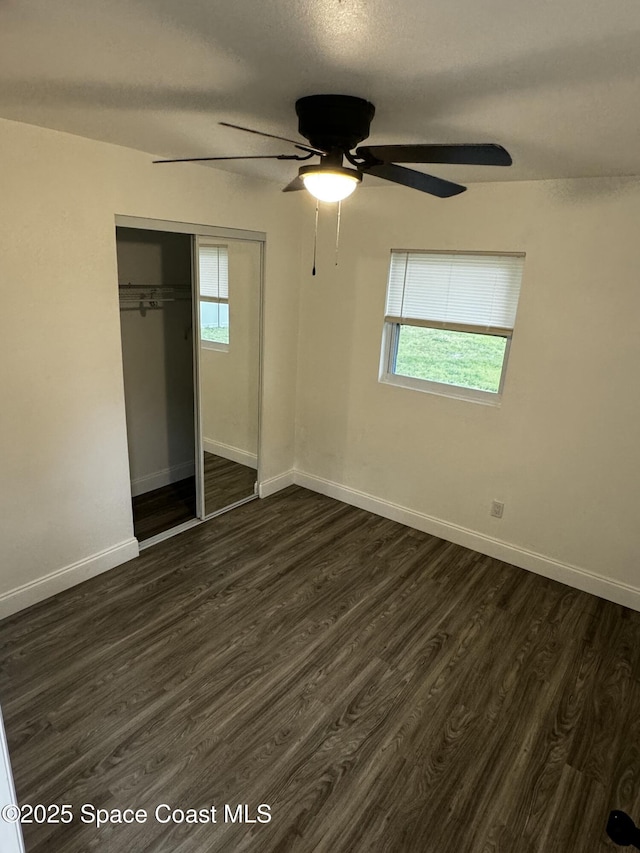 unfurnished bedroom with a closet, ceiling fan, a textured ceiling, and dark hardwood / wood-style flooring