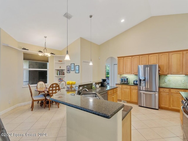 kitchen featuring light tile patterned flooring, high vaulted ceiling, pendant lighting, stainless steel appliances, and sink