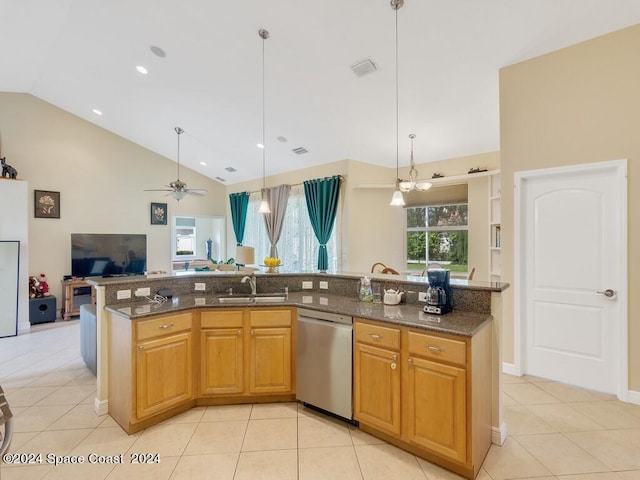 kitchen with dark stone counters, dishwasher, sink, light tile patterned floors, and ceiling fan