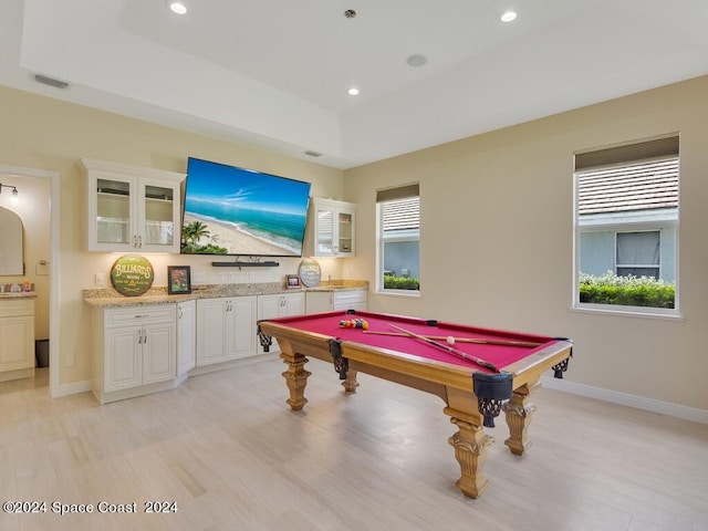 playroom featuring pool table, a raised ceiling, and light hardwood / wood-style flooring