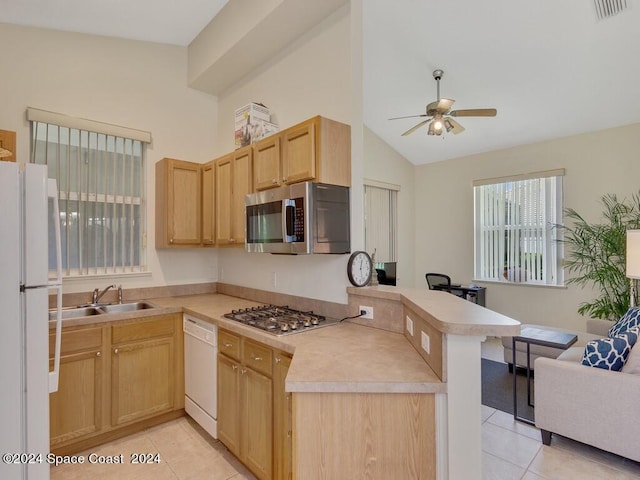 kitchen featuring light tile patterned flooring, lofted ceiling, kitchen peninsula, appliances with stainless steel finishes, and ceiling fan