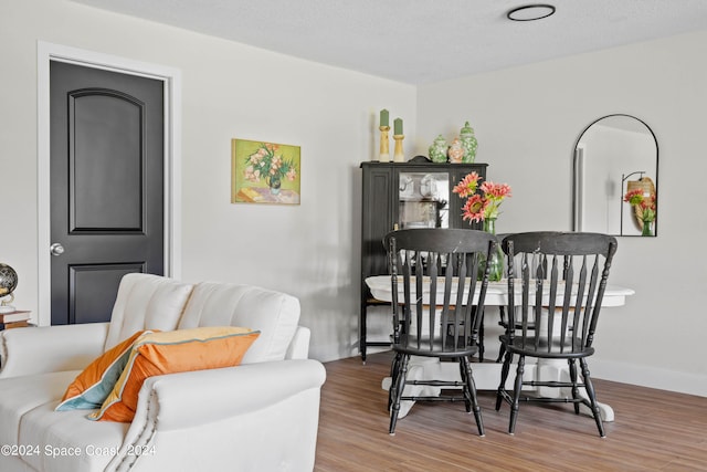 dining space with a textured ceiling and hardwood / wood-style flooring