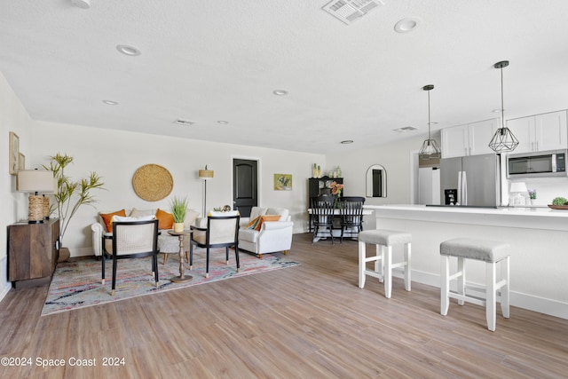 living room with light hardwood / wood-style floors and a textured ceiling