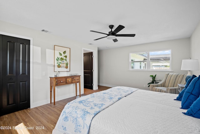 bedroom featuring ceiling fan, a closet, and hardwood / wood-style flooring