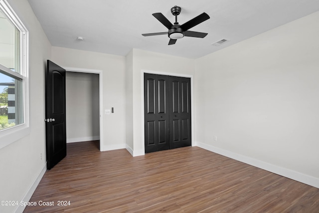 unfurnished bedroom featuring ceiling fan, a closet, and dark hardwood / wood-style flooring