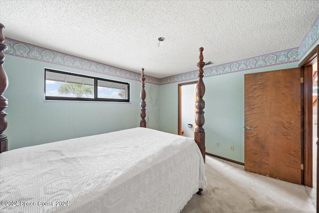 bedroom with light carpet and a textured ceiling