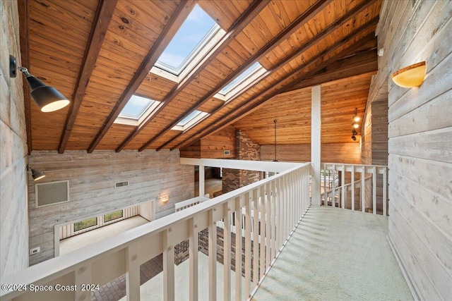 corridor with wood walls, carpet flooring, beam ceiling, wood ceiling, and high vaulted ceiling