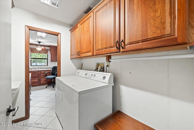 clothes washing area with ceiling fan, light tile patterned flooring, a textured ceiling, cabinets, and hookup for a washing machine