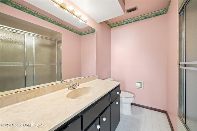 bathroom featuring tile patterned floors, an enclosed shower, vanity, and toilet