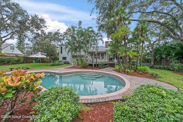 view of pool featuring a lawn and a deck