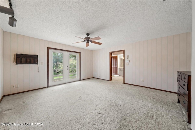 carpeted spare room with ceiling fan, french doors, and a textured ceiling