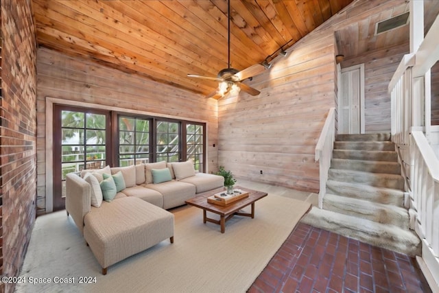 unfurnished living room with wood ceiling, high vaulted ceiling, wooden walls, and ceiling fan