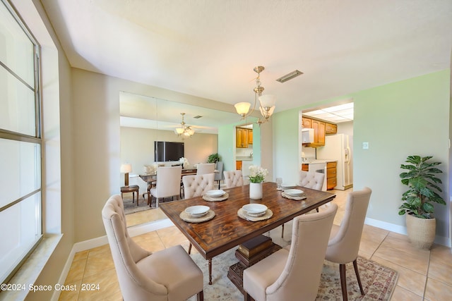 tiled dining area featuring ceiling fan with notable chandelier