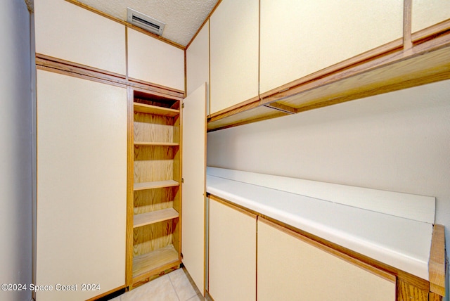 walk in closet with light tile patterned floors