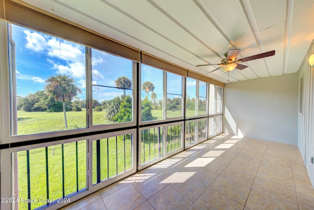 unfurnished sunroom featuring ceiling fan and a wealth of natural light