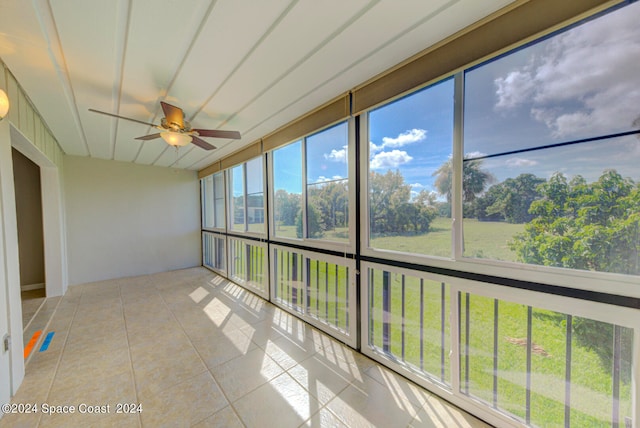 unfurnished sunroom featuring ceiling fan