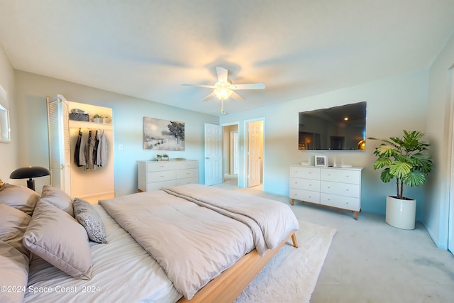 carpeted bedroom with ceiling fan and a closet