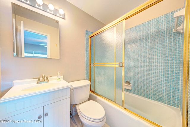 full bathroom featuring combined bath / shower with glass door, vanity, and toilet