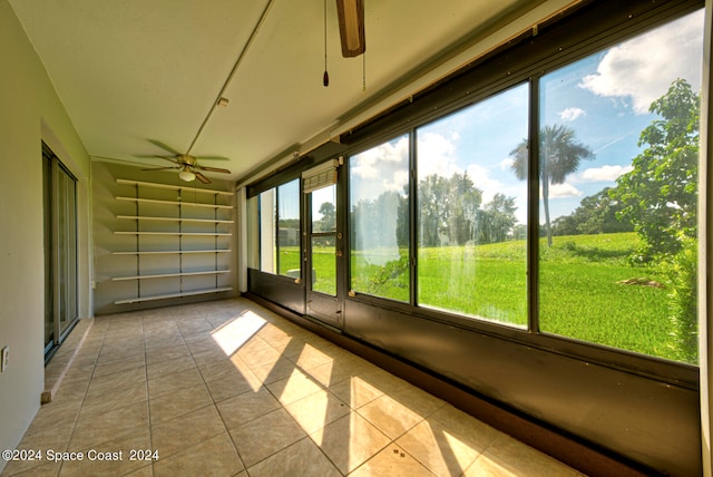 unfurnished sunroom with ceiling fan